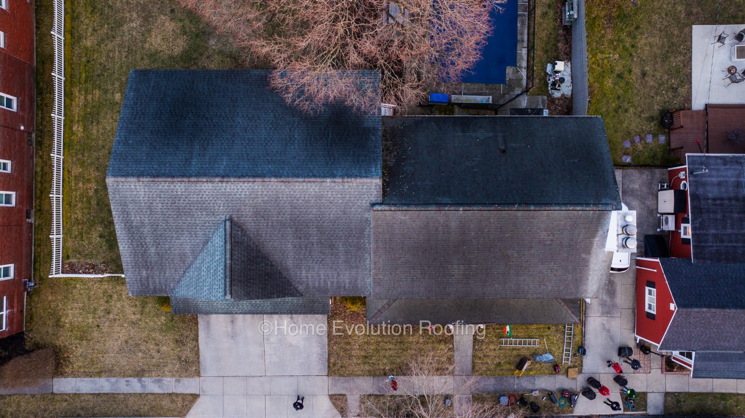 Albany roofing contractor removing black streaks caused by algae from an asphalt shingle roof using a soft wash method.