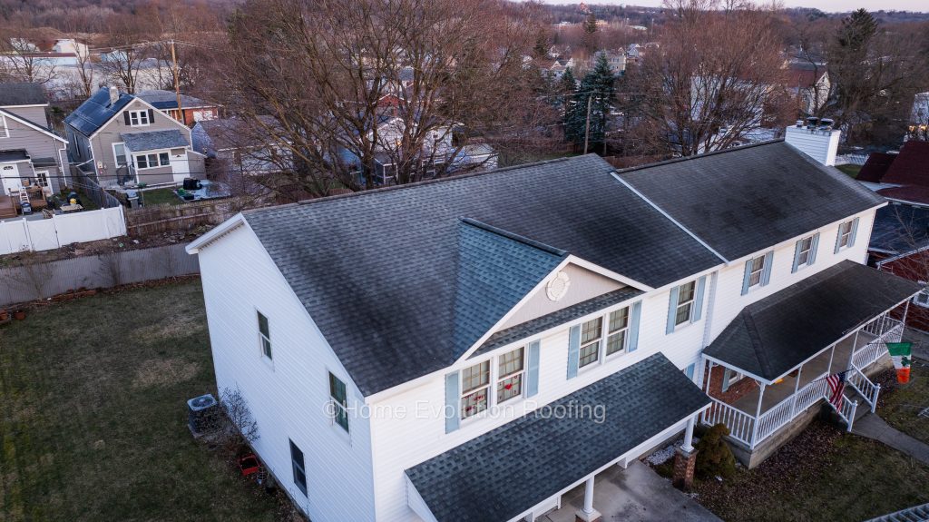 Before and after roof cleaning in Albany, NY, showing moss-covered shingles restored to their original condition