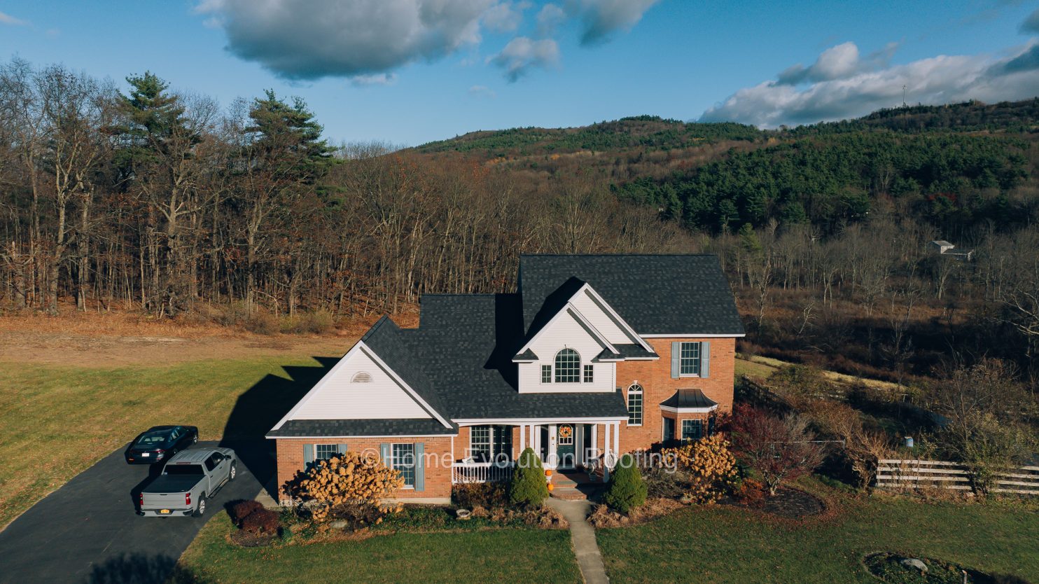 A professional roofer inspecting a roof in Gloversville NY for maintenance and repairs