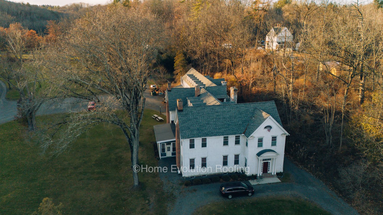 Roofing expert inspecting a flat roof in Clifton Park NY.