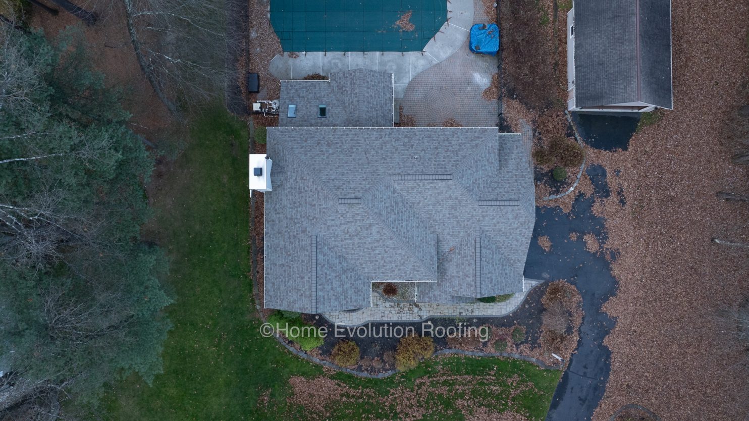 Roofers inspecting storm damage on an Albany home