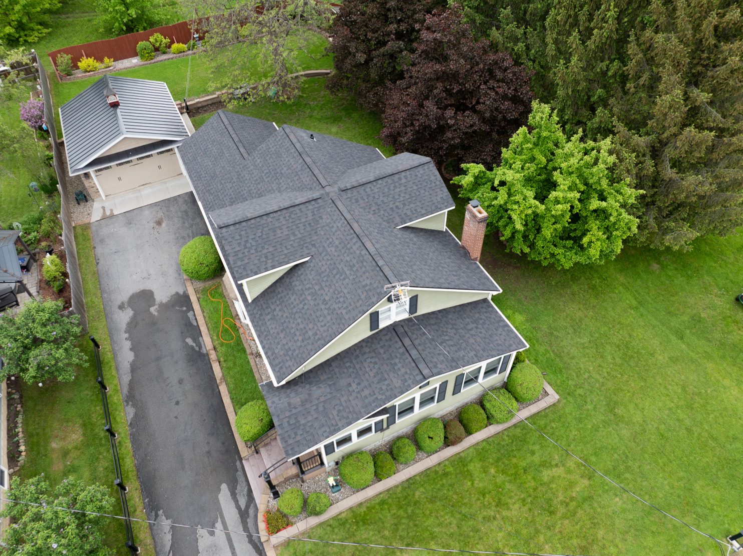 Roofing contractor inspecting home roof in Utica NY