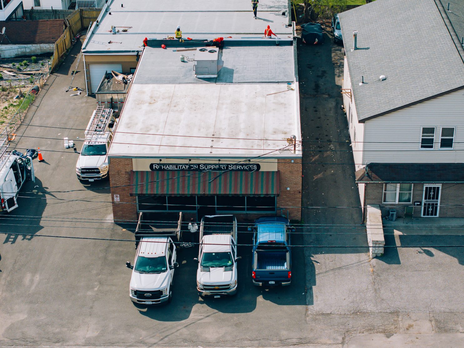 Professional roofers working on an industrial building in Utica NY