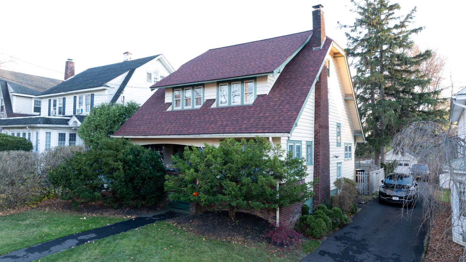 Roof repair on a historic brick building in Utica NY with preserved architectural details.