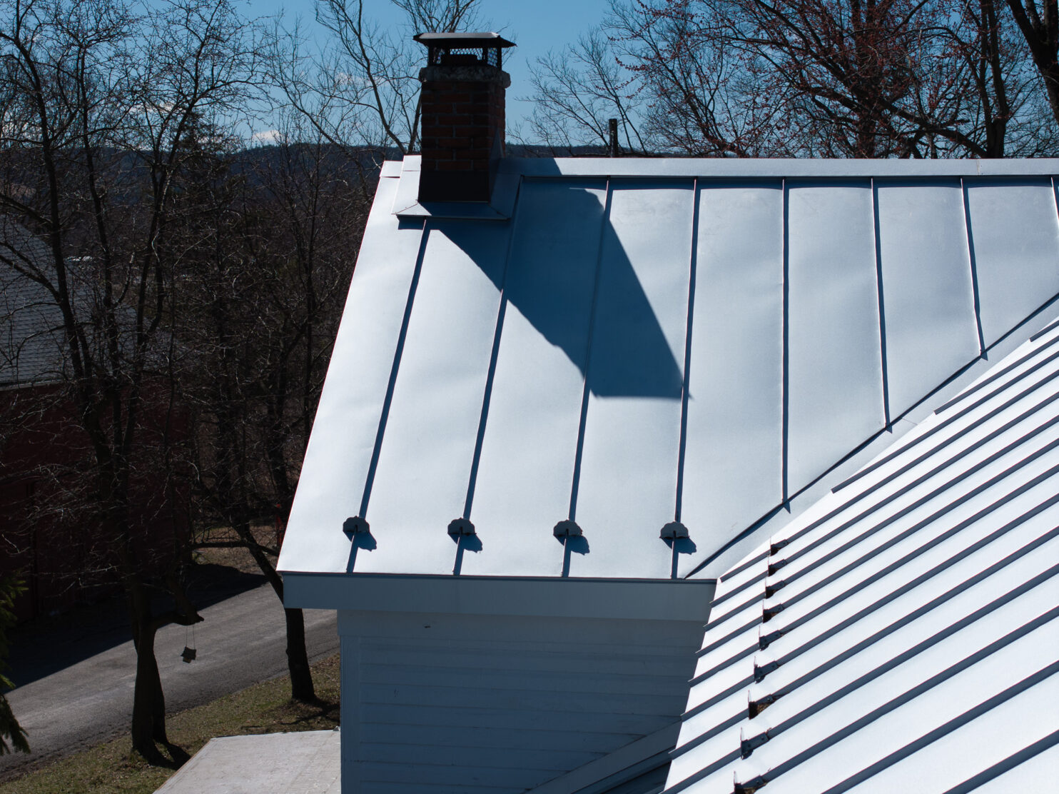 Metal roof installation on a home in Fishkill NY with modern standing seam panels.