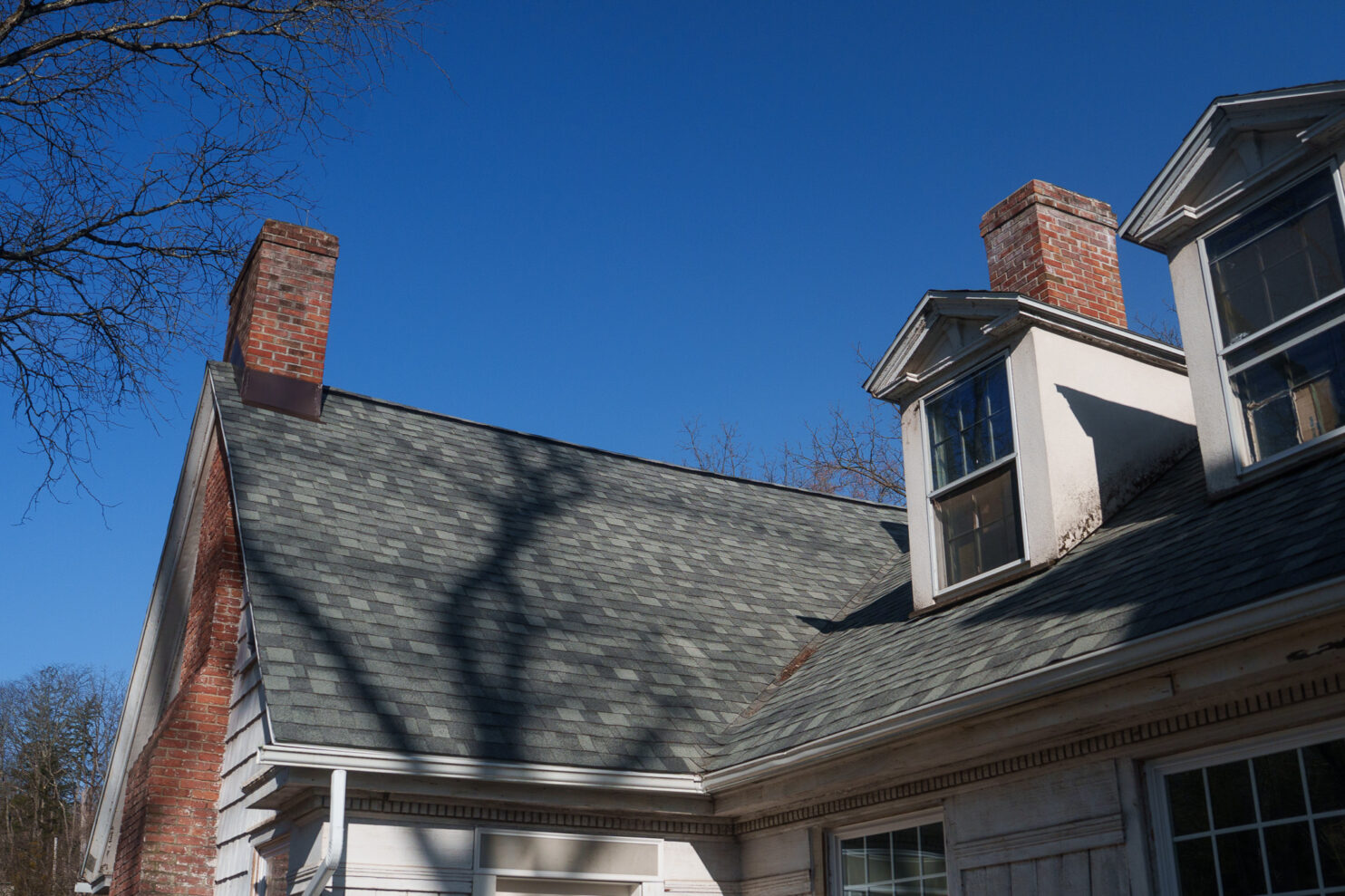 Masonry team rebuilding a brick chimney on a Utica home before winter snow.